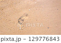 砂浜の足跡を波が消す 129776843