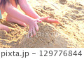 子どもが砂浜で山を作る手持ち撮影 129776844