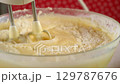 Baker mixing flour into batter with electric mixer cooking biscuit dough. 129787676