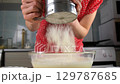 Woman pastry chef hands cooking sifting flour into bowl on kitchen. 129787685