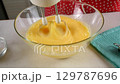 Pastry chef combining whipped egg with sugar mixing in glass bowl. 129787696