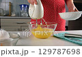 Pastry chef combining whipped egg with sugar mixing in glass bowl. 129787698