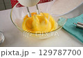 Pastry chef combining whipped egg with sugar mixing in glass bowl. 129787700