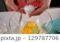 Chef woman hands cooking cracking eggs into glass bowl on kitchen. 129787706