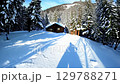 Aerial View of Winter Wonderland: Snow-covered Mountains. Allure of snowy landscapes, mountain retreats, winter tourism, and picturesque charm. zoom in, zoom out, pan, or 360 degree shot, animate 129788271