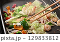 Seafood and vegetable stir-fry on a hot plate 129833812
