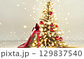 Elegant red heels escaping from a festive christmas tree scene with golden lights. Happy New Year. Merry Christmas 129837540