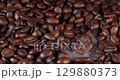 Close up of seeds of coffee. Fragrant coffee beans are roasted smoke comes from coffee beans. 129880373