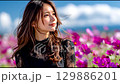 Autumn portrait of a young woman smiling in a cosmos field 129886201