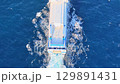 Vessel gliding through azure waters as gentle waves create rhythmic patterns against its hull 129891431