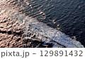 Waves crash and shimmer under golden sunlight across the endless ocean on a calm afternoon 129891432