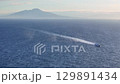 Sailing across the tranquil waters with a distant volcano framing the serene horizon during golden hour 129891434