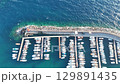 Boats nestled in the tranquil waters of a coastal marina at sunset offering a picturesque view of a vibrant harbor 129891435
