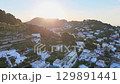 Hidden gems of a serene Italian island basking in warm sunset glow over charming coastal homes 129891441