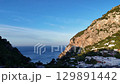 Majestic coastal view of cliffs meeting the serene blue sea during golden hour in a picturesque Italian village 129891442