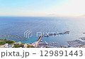 Breathtaking coastal view of a serene harbor with boats at sunset 129891443