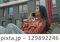 Stylish Asian Woman Talking On Smartphone In Modern Urban Environment 129892246