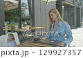 Businesswoman Starts Laptop Work At Outdoor Cafe Table In Morning Light 129927357