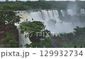 Aerial view of Iguazu Falls jungle cliffs and river with mist rising high 129932734