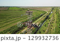 Tall tower with nesting storks over fields and pastureland 129932736
