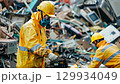 In an industrial environment, skilled workers are actively dismantling electronic waste to facilitate proper recycling and recovery of valuable materials for environmental sustainability 129934049