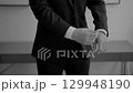 Man adjusting suit sleeves in black and white slow motion. 129948190