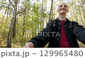 Young man leading girlfriend through forest holding hands 129965480