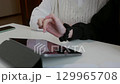 Woman showing tablet screen to colleague 129965708