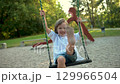 Adorable little boy having fun on a playground on bright sunny summer day. 129966504