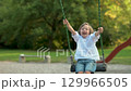 Adorable little boy having fun on a playground on bright sunny summer day. 129966505
