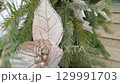 Festive holiday garlands adorn pine branches in wintery outdoor decoration 129991703