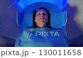 Portrait Shot of a Female Patient Lying on a CT or MRI Scan, Bed is Moving Inside the Machine While it Scans Her Body and Brain. In Medical Laboratory with High-Tech Equipment. Top Down View 130011658