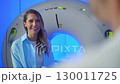 Doctor talking to patient before MRI. Portrait patient talking about symptoms before tomography. Portrait Patient sitting at CT scanner doctor adjusting MRI capsule. Conducting advanced imaging 130011725