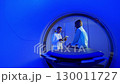Handsome Caucasian Doctor talking to patient before MRI. Patient talking about symptoms before tomography. Patient sitting at CT scanner doctor adjusting MRI capsule. Conducting advanced imaging 130011727