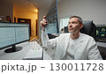 Medic expert holding x ray imaging test results. Handsome Caucasian male reviewing diagnostic results. Concentrating inside radiology room. Neuroscientist Finding Treatment X-ray Scan MRI CT Scan 130011728