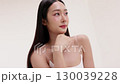 Skincare commercial video featuring a young Asian woman applying natural cosmetic cream in a soft, minimal studio setting. Ideal for promoting beauty, self-care, and organic skincare products. 130039228
