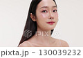 Skincare commercial video featuring a young Asian woman applying natural cosmetic cream in a soft, minimal studio setting. Ideal for promoting beauty, self-care, and organic skincare products. 130039232