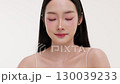 Skincare commercial video featuring a young Asian woman applying natural cosmetic cream in a soft, minimal studio setting. Ideal for promoting beauty, self-care, and organic skincare products. 130039233