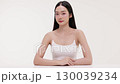 Skincare commercial video featuring a young Asian woman applying natural cosmetic cream in a soft, minimal studio setting. Ideal for promoting beauty, self-care, and organic skincare products. 130039234