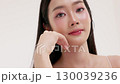 Skincare commercial video featuring a young Asian woman applying natural cosmetic cream in a soft, minimal studio setting. Ideal for promoting beauty, self-care, and organic skincare products. 130039236