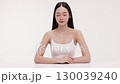 Skincare commercial video featuring a young Asian woman applying natural cosmetic cream in a soft, minimal studio setting. Ideal for promoting beauty, self-care, and organic skincare products. 130039240