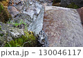 A 4x slow motion close up of small natural spring of clear water flowing from old rusty metal trough next to moss and lichen covered rocks. Natural water reserves and self cleaning in flowing process 130046117