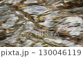 Slow motion close-up of the surface of a mountain river with clear cold water, on which waves are formed due to the collision of the flow with underwater rocks. Relaxing footage of natural environment 130046119
