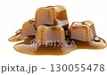 Sweet melted caramel cubes, white background, slow motion 130055478