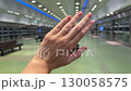 Platinum engagement ring, wedding band displayed on a hand while traveling through a brightly lit underground metro station with urban lifestyle detail. 130058575