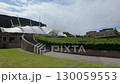 Pan across Dynamic Earth exhibition Edinburgh with Salisbury Crags in the background. Shot on a windy summer day  130059553
