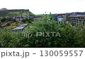 Elevated pan across Holyrood district Edinburgh with Salisbury Crags in background  130059557