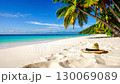 Straw hat lies on idyllic tropical beach under palm trees. 130069089