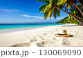 Relaxing tropical beach with white sand, turquoise water, palm trees, and straw hat. 130069090