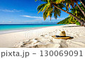 Relaxing tropical beach with white sand, turquoise water, palm trees, and straw hat. 130069091